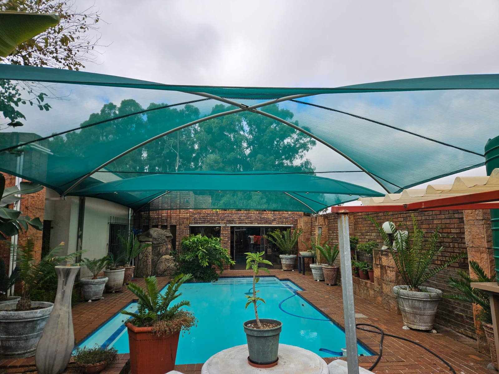 Green shade sails covering a pool